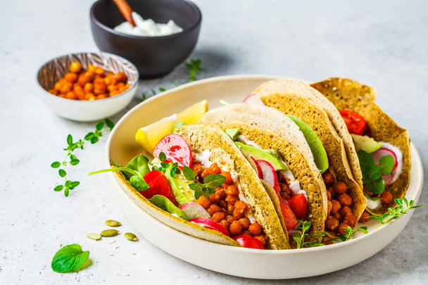 Vegan tacos with baked chickpeas, avocado, sauce and vegetables  - Photo, image
