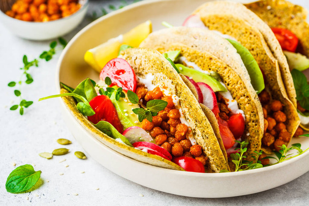 Vegan tacos with baked chickpeas, avocado, sauce and vegetables  - Фото, изображение
