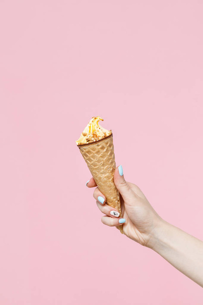 Woman holding Ice Cream in a waffles cone on color background. - Fotoğraf, Görsel