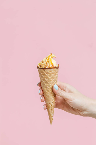 Woman holding Ice Cream in a waffles cone on color background. - 写真・画像