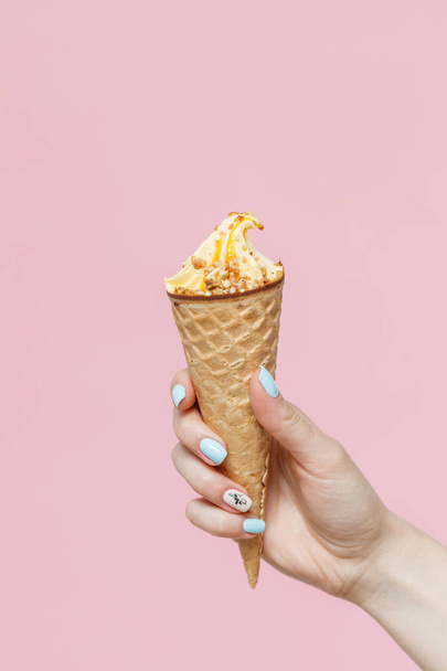 Woman holding Ice Cream in a waffles cone on color background. - Φωτογραφία, εικόνα