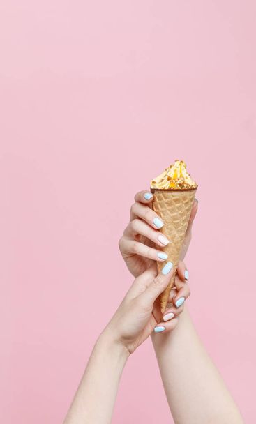 Woman holding Ice Cream in a waffles cone on color background. - Fotó, kép