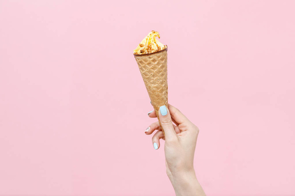Woman holding Ice Cream in a wafflescone on color background. - Φωτογραφία, εικόνα