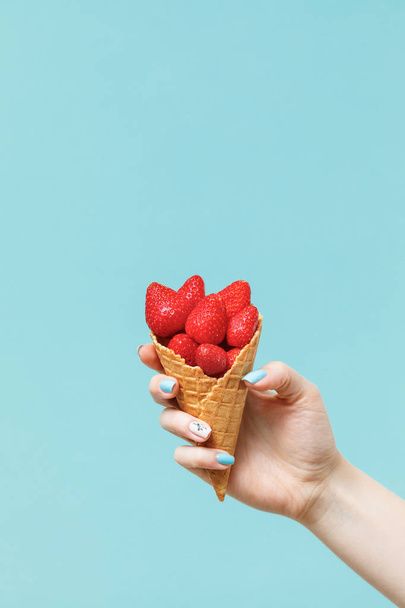 Waffle cone with strawberries  in female hand. Fresh summer fruits. - Fotoğraf, Görsel
