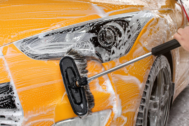 Front bumper and light of a yellow car washed in self serve carw - Fotografie, Obrázek