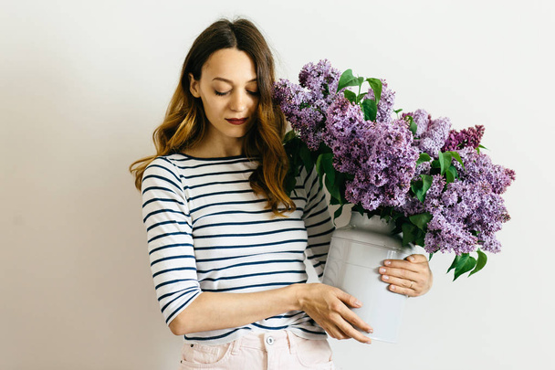 Atraktivní dívka s kyticí fialovou na bílém pozadí - Fotografie, Obrázek