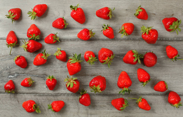 Tabletop view - ripe strawberries, freshly picked spilled on gra - Fotografie, Obrázek