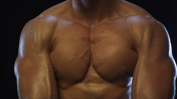 młody dopasowany facet pokazując mięśnie klatki piersiowej - Materiał filmowy, wideo