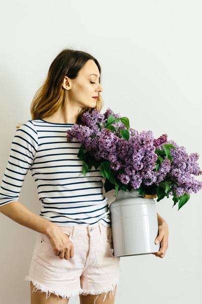 Attractive girl with a bouquet of lilac on a white background - Foto, imagen