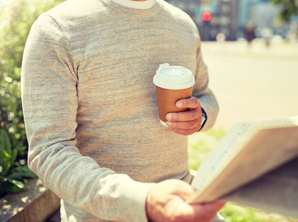senior man with coffee reading newspaper outdoors - Photo, image