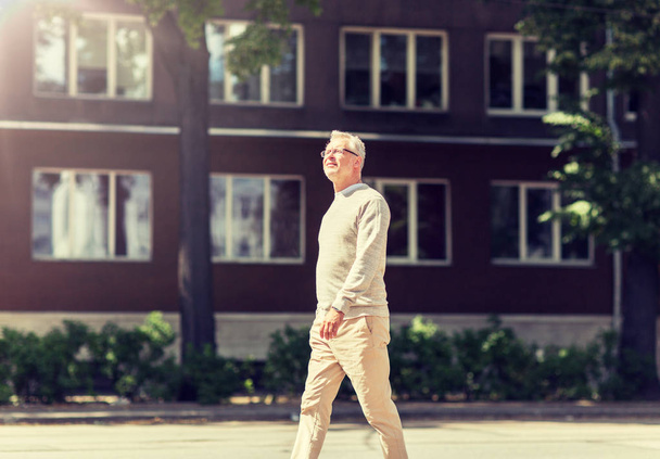 senior man walking along summer city street - Zdjęcie, obraz