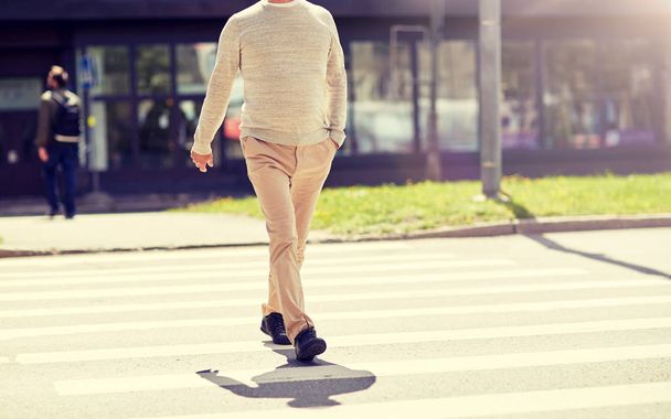 senior man walking along city crosswalk - Fotoğraf, Görsel