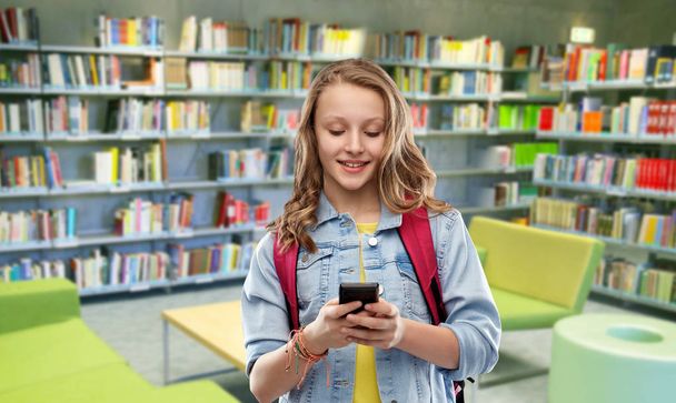 teenage student girl with smartphone at library - Foto, Imagem