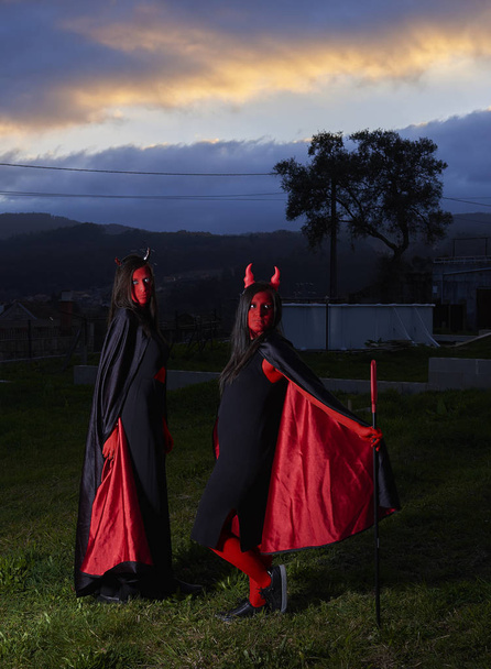 Due giovani donne in costume da diavolo ad Halloween
 - Foto, immagini