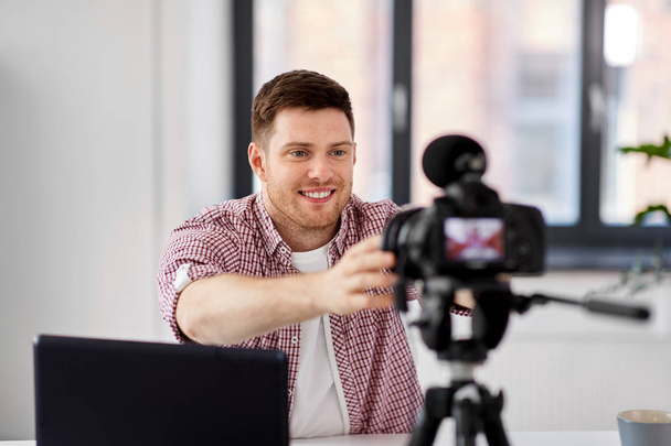 male video blogger adjusting camera at home office - Photo, image