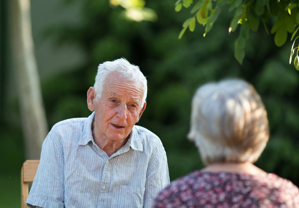 Alter Mann und Frau unterhalten sich im Park - Foto, Bild