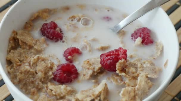 Poner frambuesas frescas en un tazón de desayuno de cereales
 - Metraje, vídeo