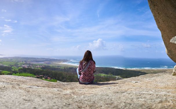 Mladá žena se dívá na moře z výšky - Fotografie, Obrázek