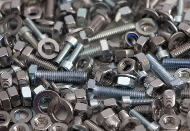 various, various bolts, nuts, screws and washers lying all together in a heap, top view - Photo, Image