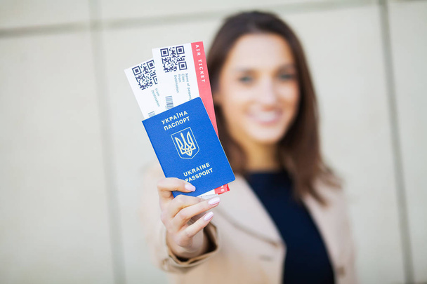 旅行。空港近くの海外のパスポートに2つの航空券を持っている女性 - 写真・画像