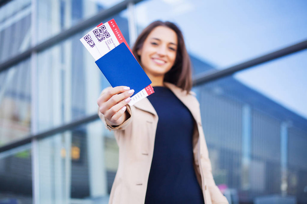 Matkustaa. Nainen, jolla on kaksi lentolippu ulkomailla passi lähellä lentokenttää
 - Valokuva, kuva