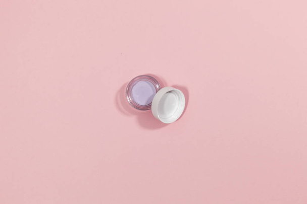 A white bottle and cap are on a pink surface - Foto, afbeelding