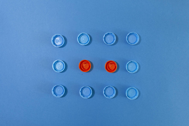 Kék és piros színű sapkák csoportja kék felületen - Fotó, kép