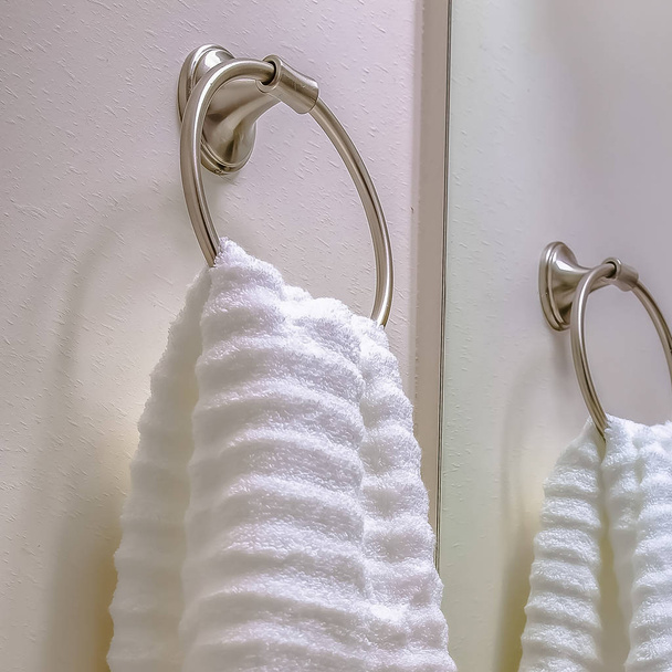 Quadro quadrado Interior do banheiro com vista de perto de uma toalha branca pendurada em um anel de toalha
 - Foto, Imagem
