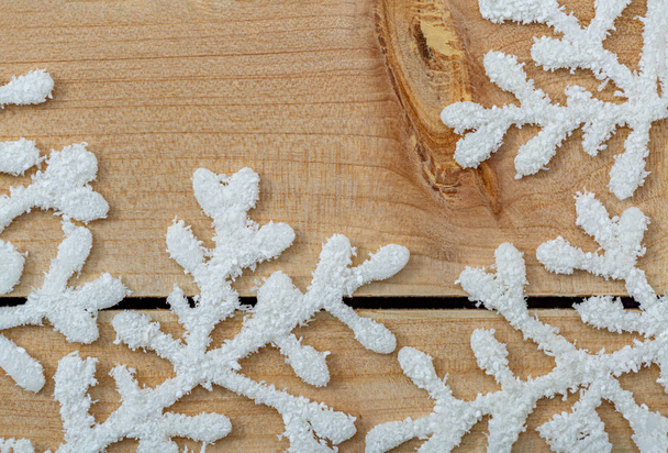 Fehér hópelyhek egy világos fából készült asztal. Karácsonyi dekoráció háttér-és másolási hely. Boldog Karácsonyt és új évet!.  - Fotó, kép