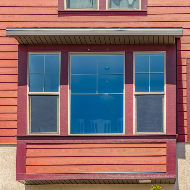 Окно дома с отделкой из дерева и нейтральной наружной стеной
 - Фото, изображение