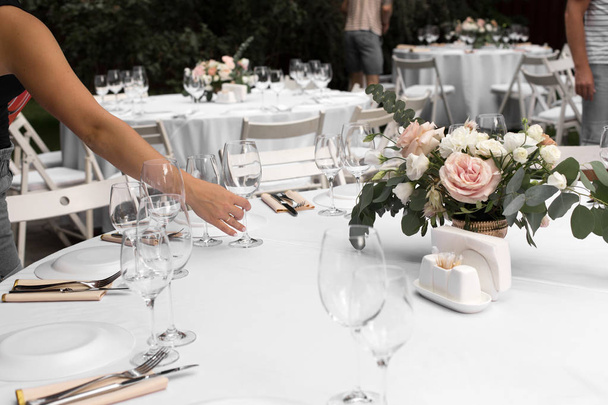 The waiter serves banquet table. Wedding table setting decorated - Fotoğraf, Görsel