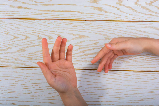 Mains faisant un geste sur fond en bois
 - Photo, image