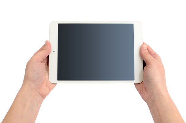 Τα χέρια κρατούν ένα gadget σε λευκό φόντο. Υπολογιστής tablet, ασύρματη συσκευή. - Φωτογραφία, εικόνα
