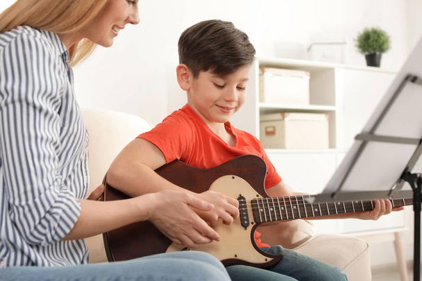 Little boy playing guitar with his teacher at music lesson. Learning notes - Φωτογραφία, εικόνα