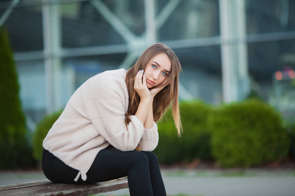 Mulher deprimida sentada em um parque da cidade em um banco
 - Foto, Imagem