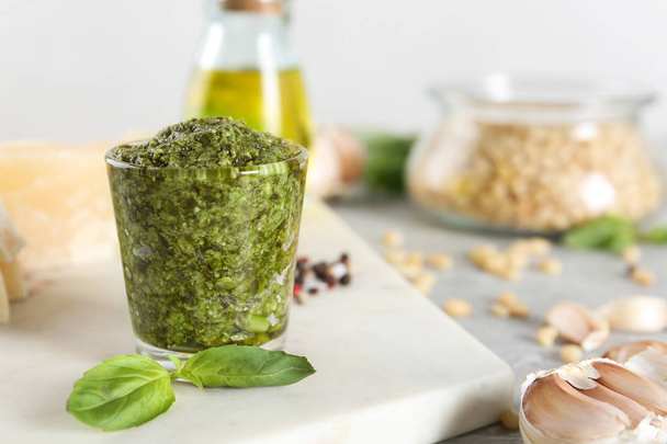 Board with glass of pesto sauce and basil on table. Space for text - Foto, immagini