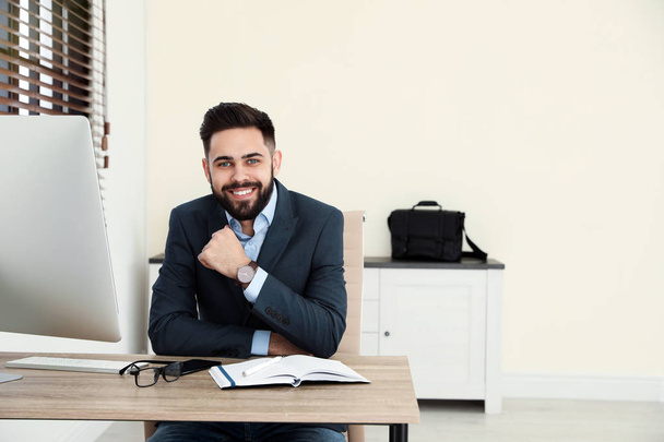 Handsome businessman working at table in office - Foto, immagini