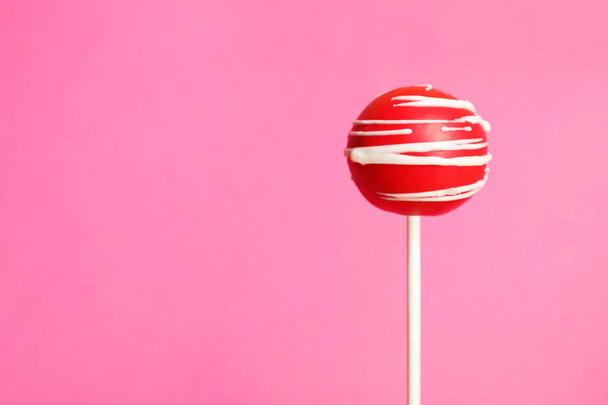 Bright delicious cake pop on color background. Space for text - 写真・画像