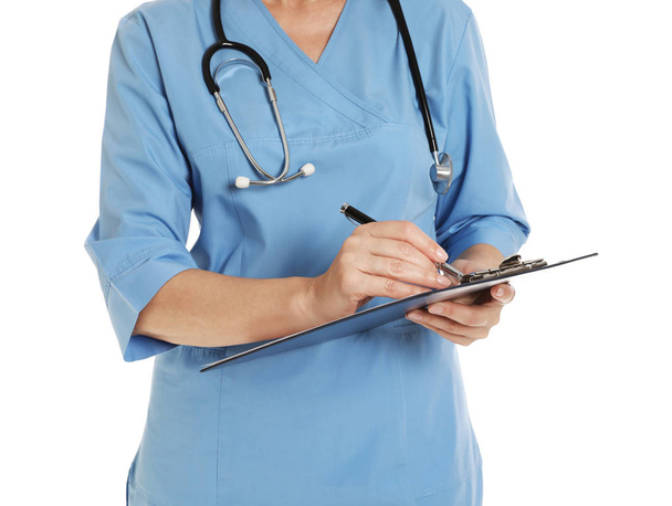 Closeup of female doctor in scrubs with clipboard isolated on white. Medical staff - Photo, image