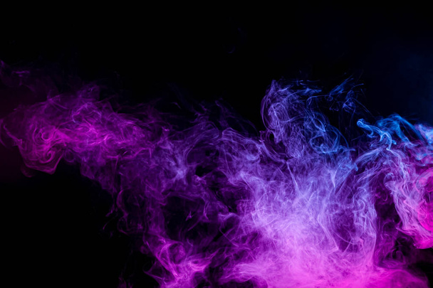Close up vorticoso fumo rosa e blu su backgroun isolato nero
 - Foto, immagini