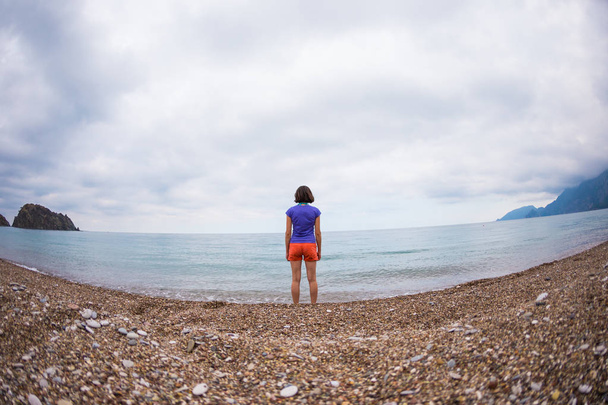 Una mujer camina sola en la costa del mar
. - Foto, imagen