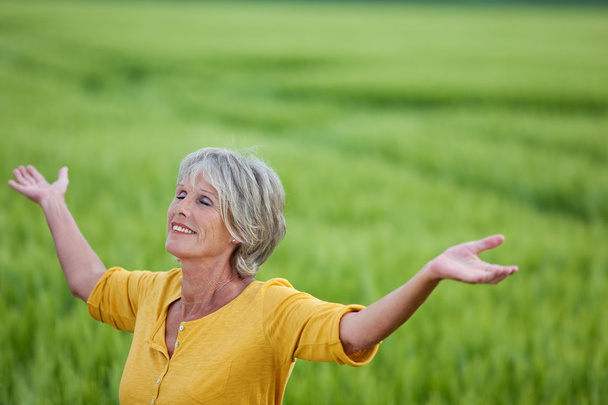 Senior Woman Enjoying Nature On Grassy Field - Foto, Bild