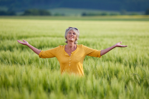 Senior Woman Enjoying Nature On Grassy Field - Фото, изображение
