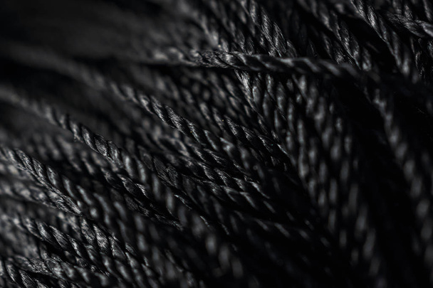 black threads are wound in a bobbin. Macro    - Photo, Image