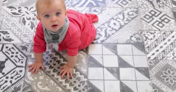 Ihana lapsi punaisessa pyjamassa ryömii lattialla
 - Materiaali, video