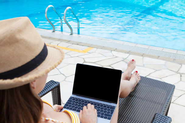 Молодая женщина с ноутбуком возле бассейна
 - Фото, изображение