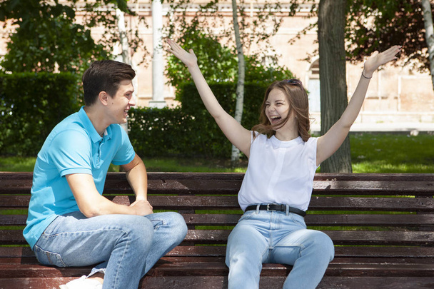 beautiful young couple sitting on a bench in the park - Foto, Imagem