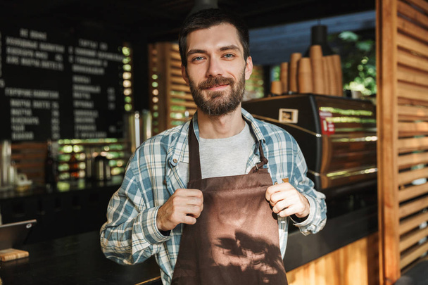 Portrait of european barista guy working in street cafe or coffe - Fotó, kép