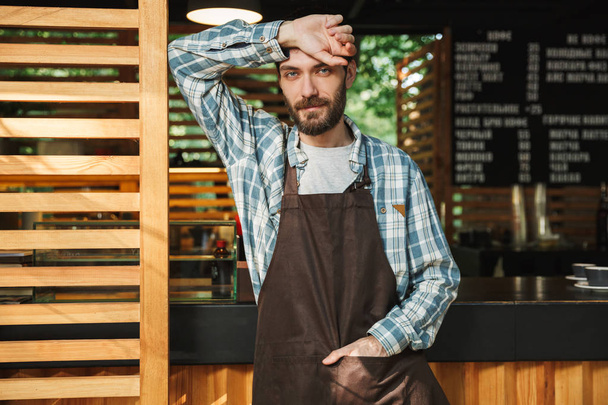 Portrait of handsome barista man working in street cafe or coffe - Photo, Image