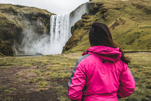 Reisende reisen zum Skogafoss Wasserfall in Island. - Foto, Bild